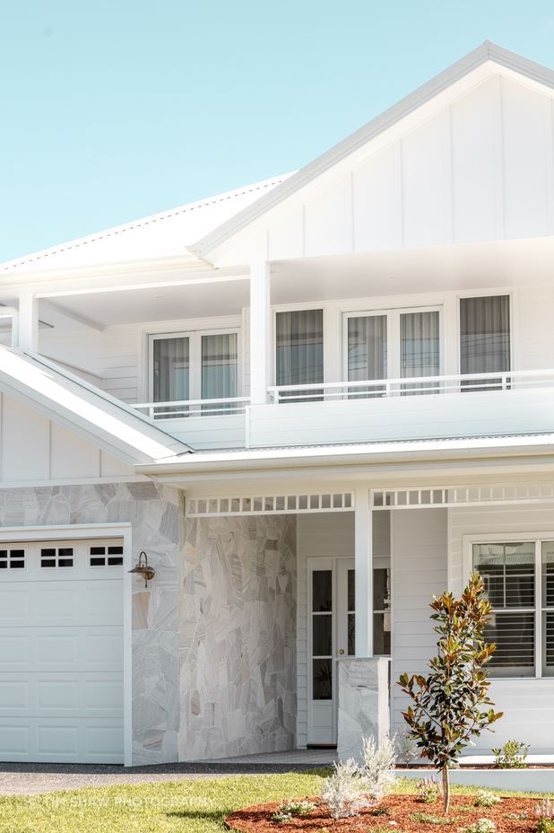 Natural stone breaks the all-white façade, reflecting the surrounding sand dunes.