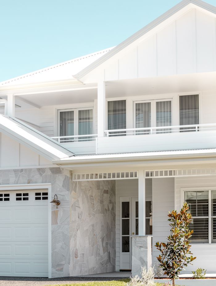 Natural stone breaks the all-white façade, reflecting the surrounding sand dunes.