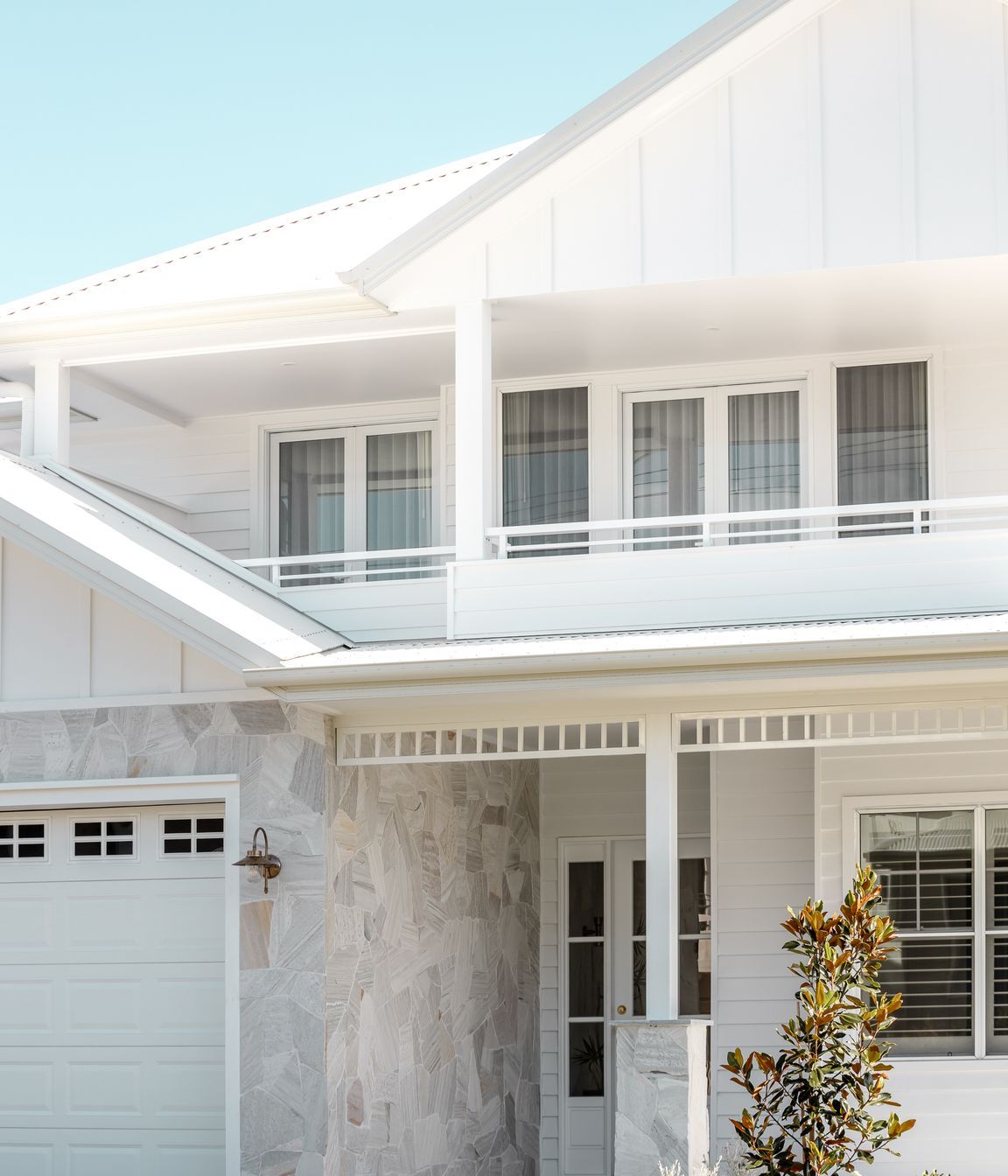 Natural stone breaks the all-white façade, reflecting the surrounding sand dunes.