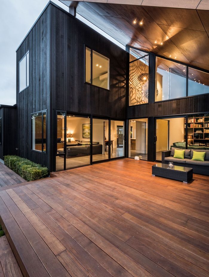 From the back of the house, the deck is tucked under the roof that looks as if magically propped up against the 'box' form of the house.