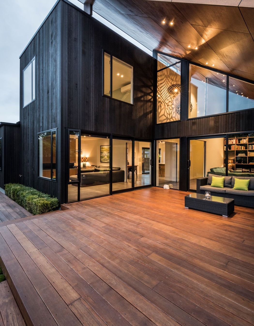 From the back of the house, the deck is tucked under the roof that looks as if magically propped up against the 'box' form of the house.