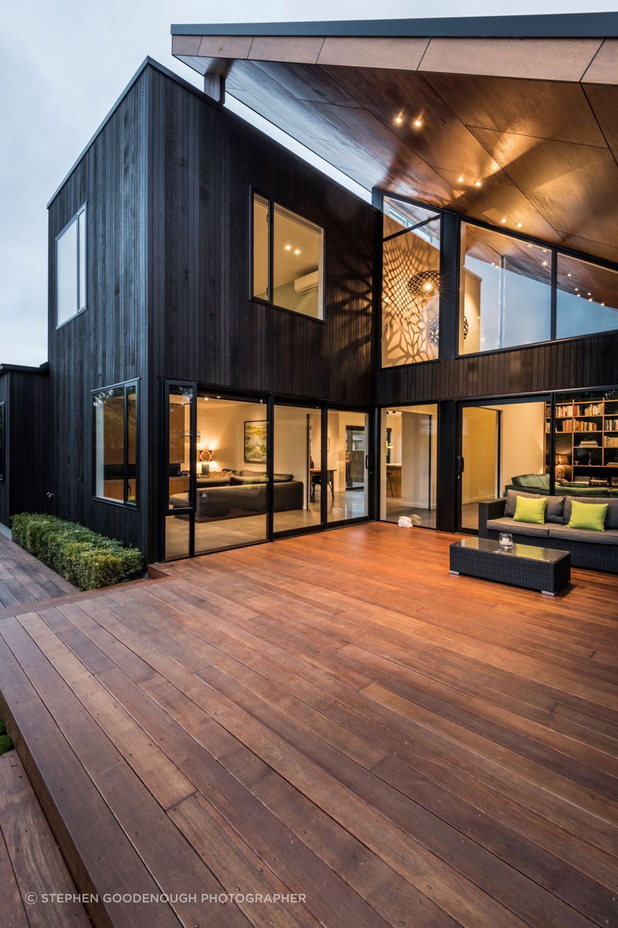 From the back of the house, the deck is tucked under the roof that looks as if magically propped up against the 'box' form of the house.