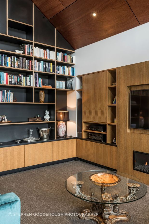 The glossy ply ceiling juxtaposes beautifully with the exquisitely made timber shelving and built-in elements.