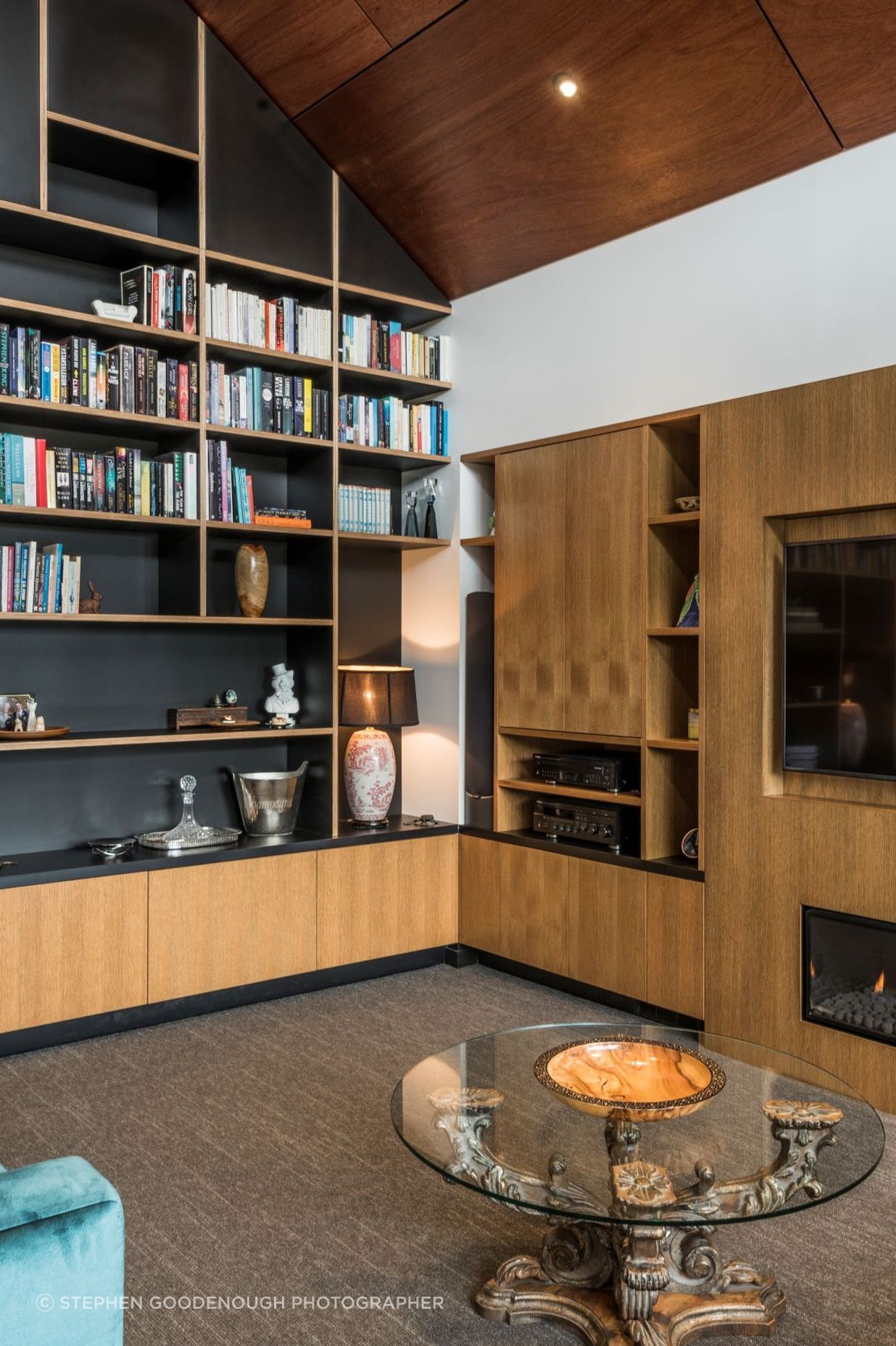 The glossy ply ceiling juxtaposes beautifully with the exquisitely made timber shelving and built-in elements.