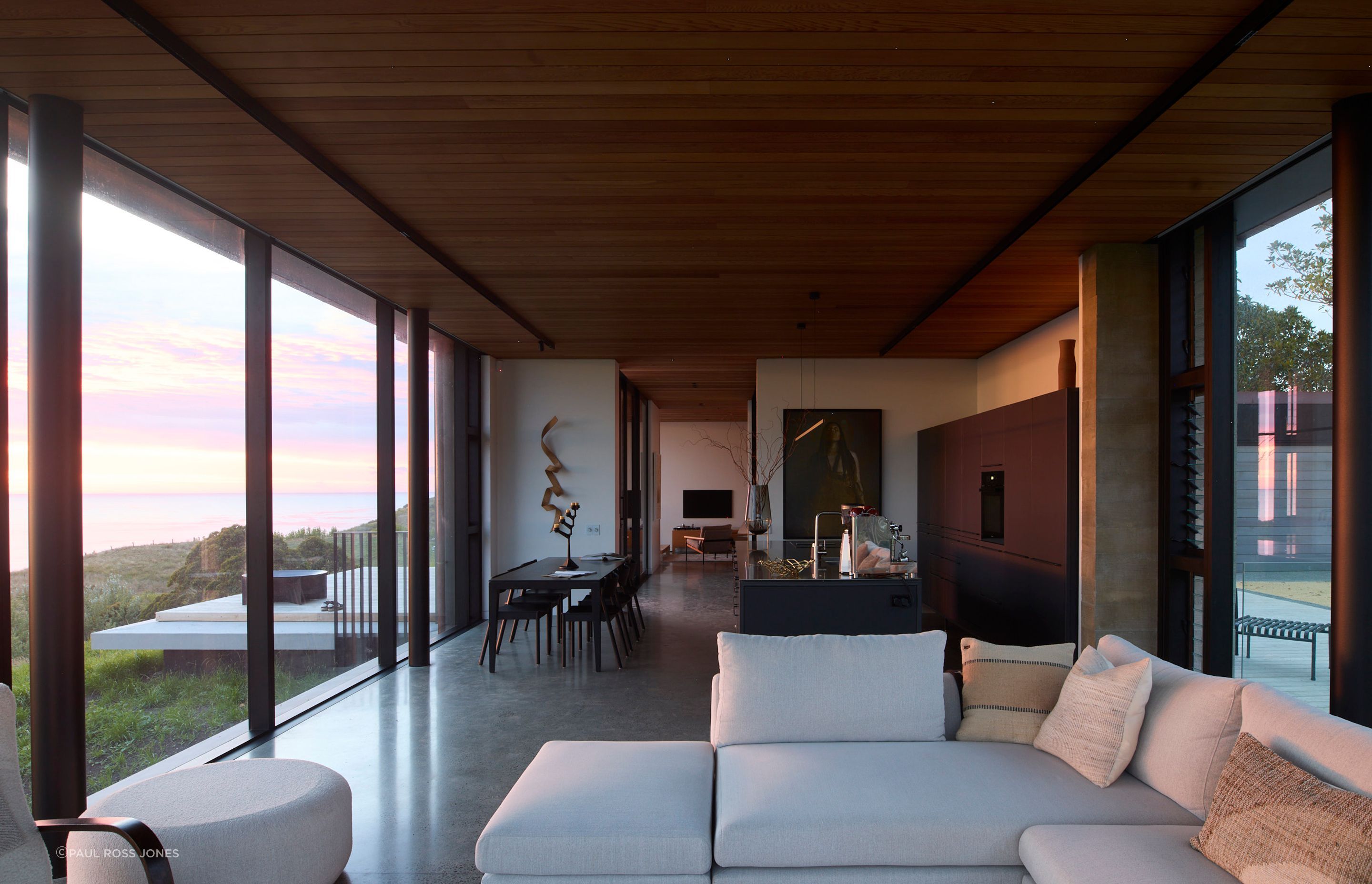 The living room invites light through all sides