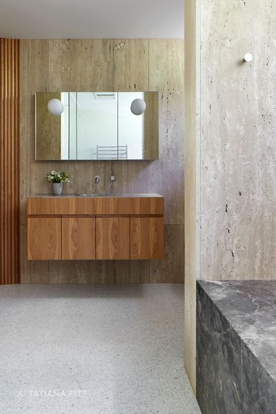 A view of the wood veneer vanity from the marble bath.