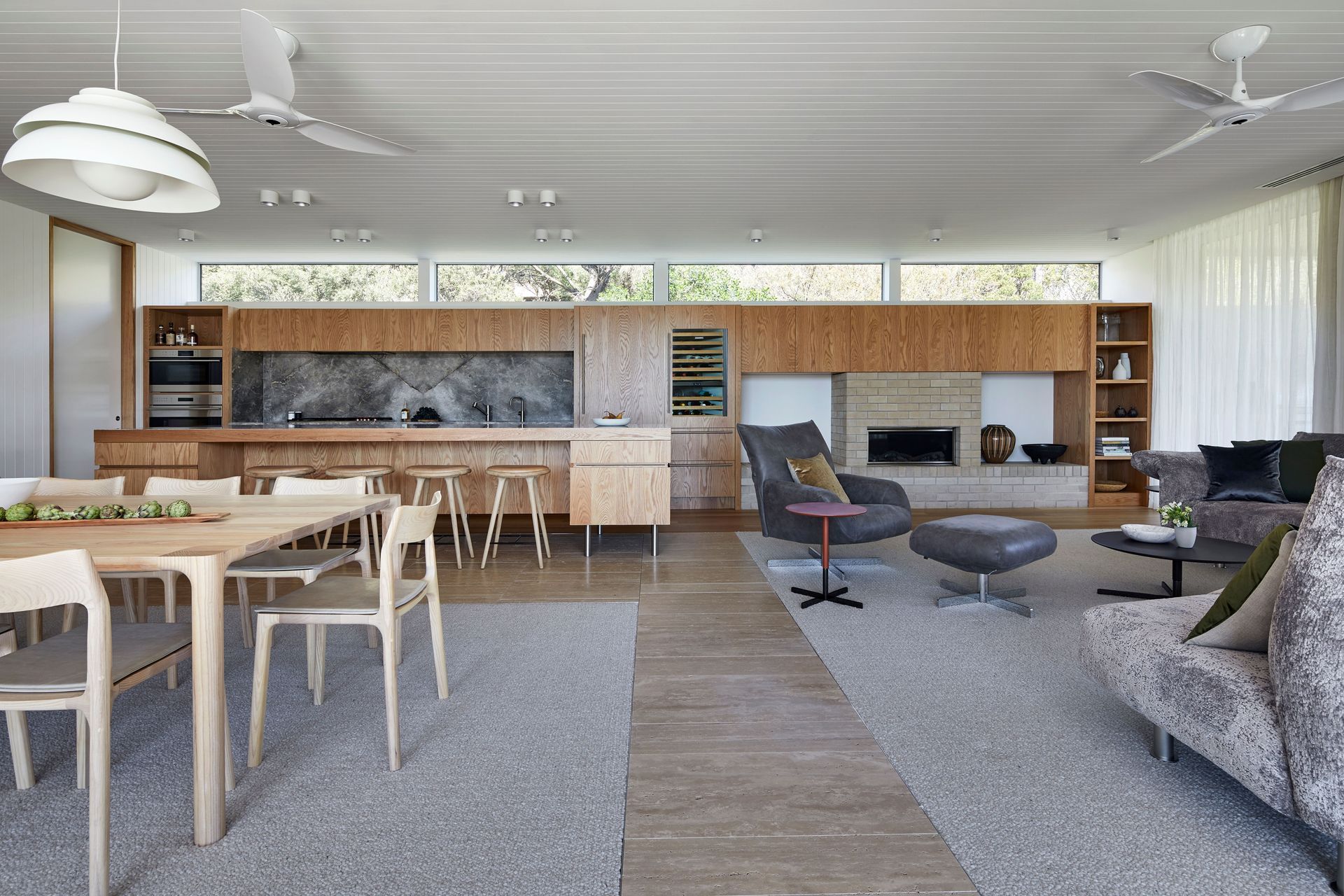 The open plan kitchen, dining and living room is cleverly zoned with Italian travertine limestone tiles.