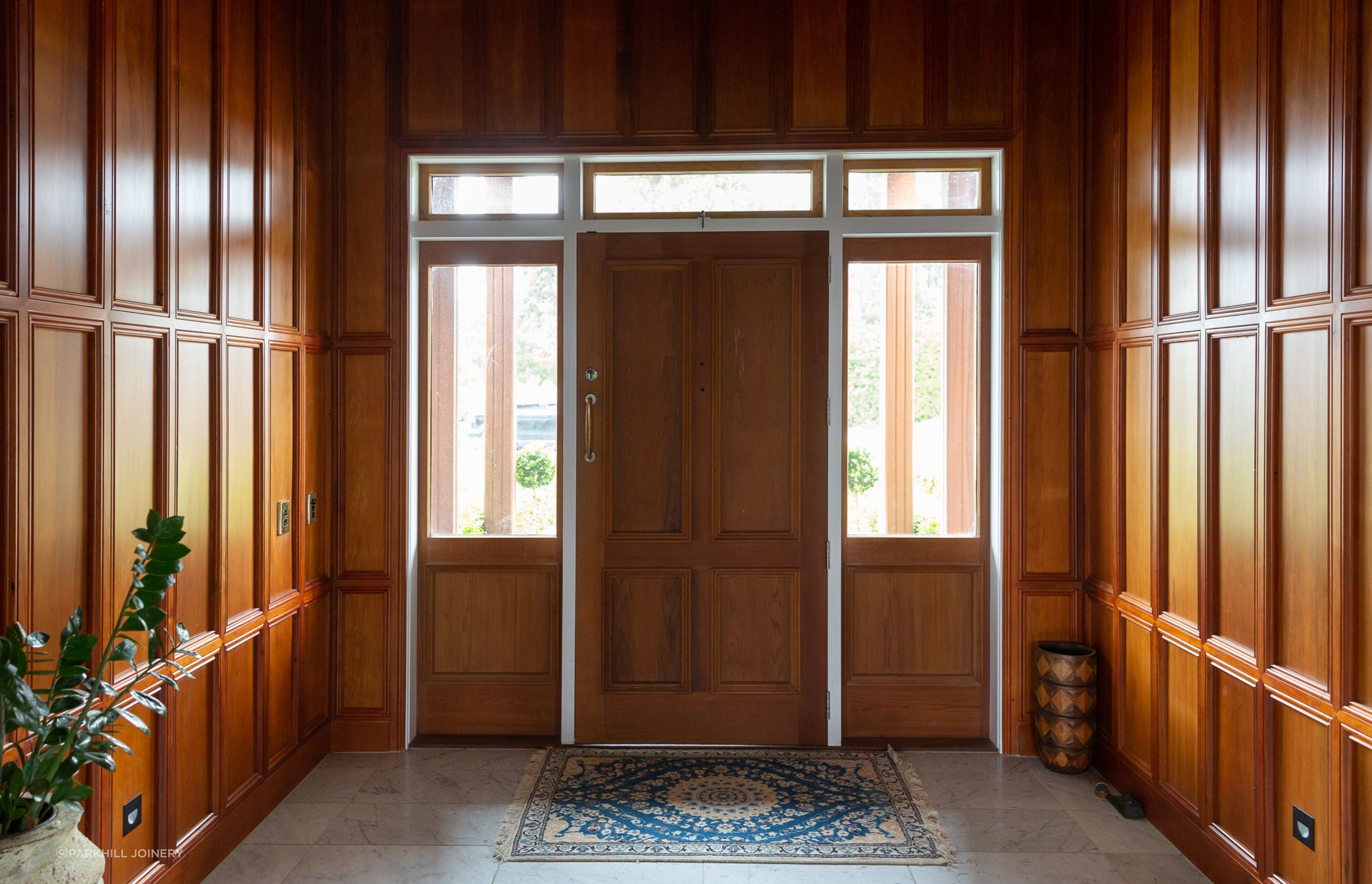 Custom jarra wood panelling makes a statement to the entry.