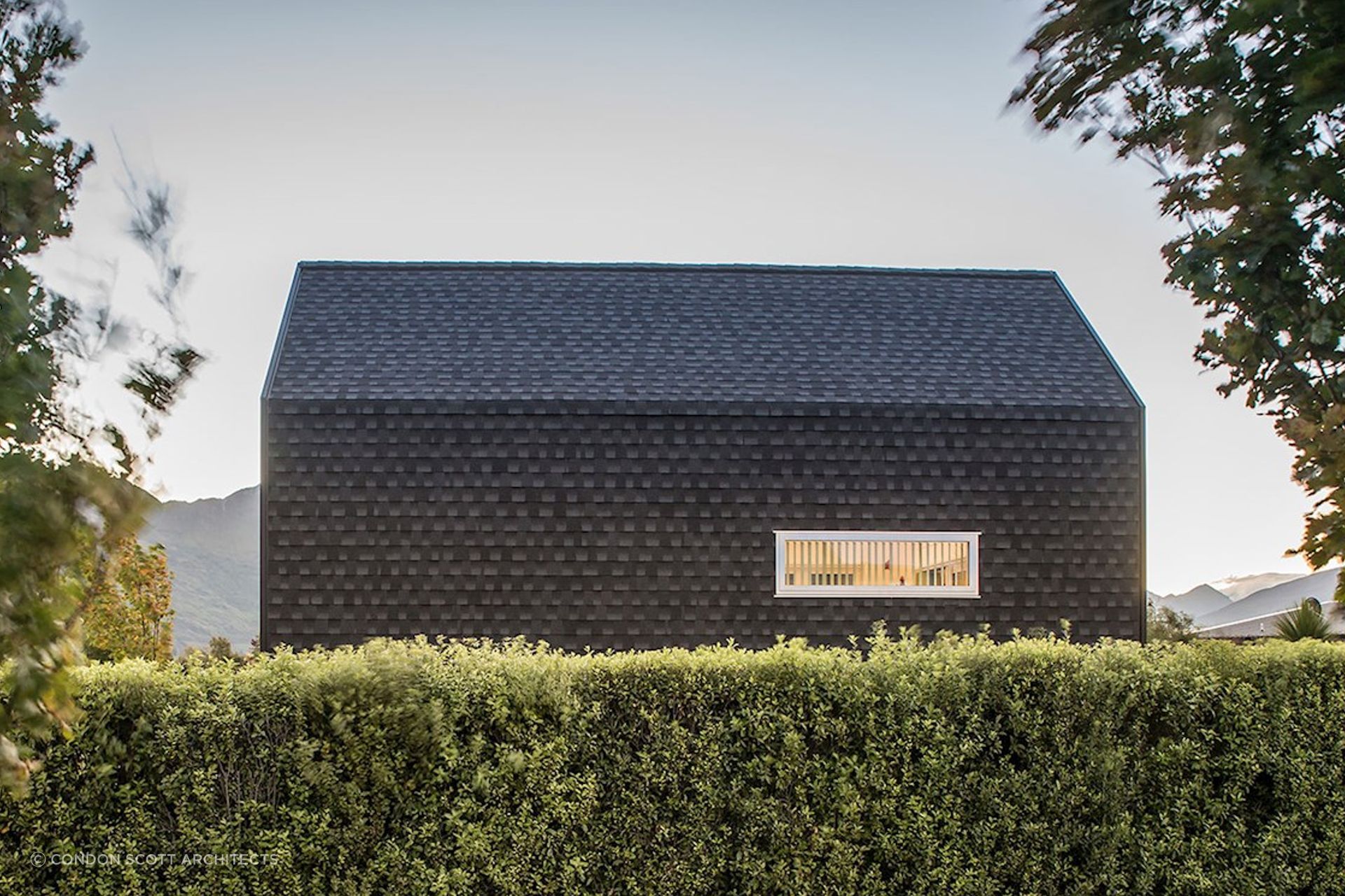 A bold kerbside view from across the hedge of the Kimimoko House