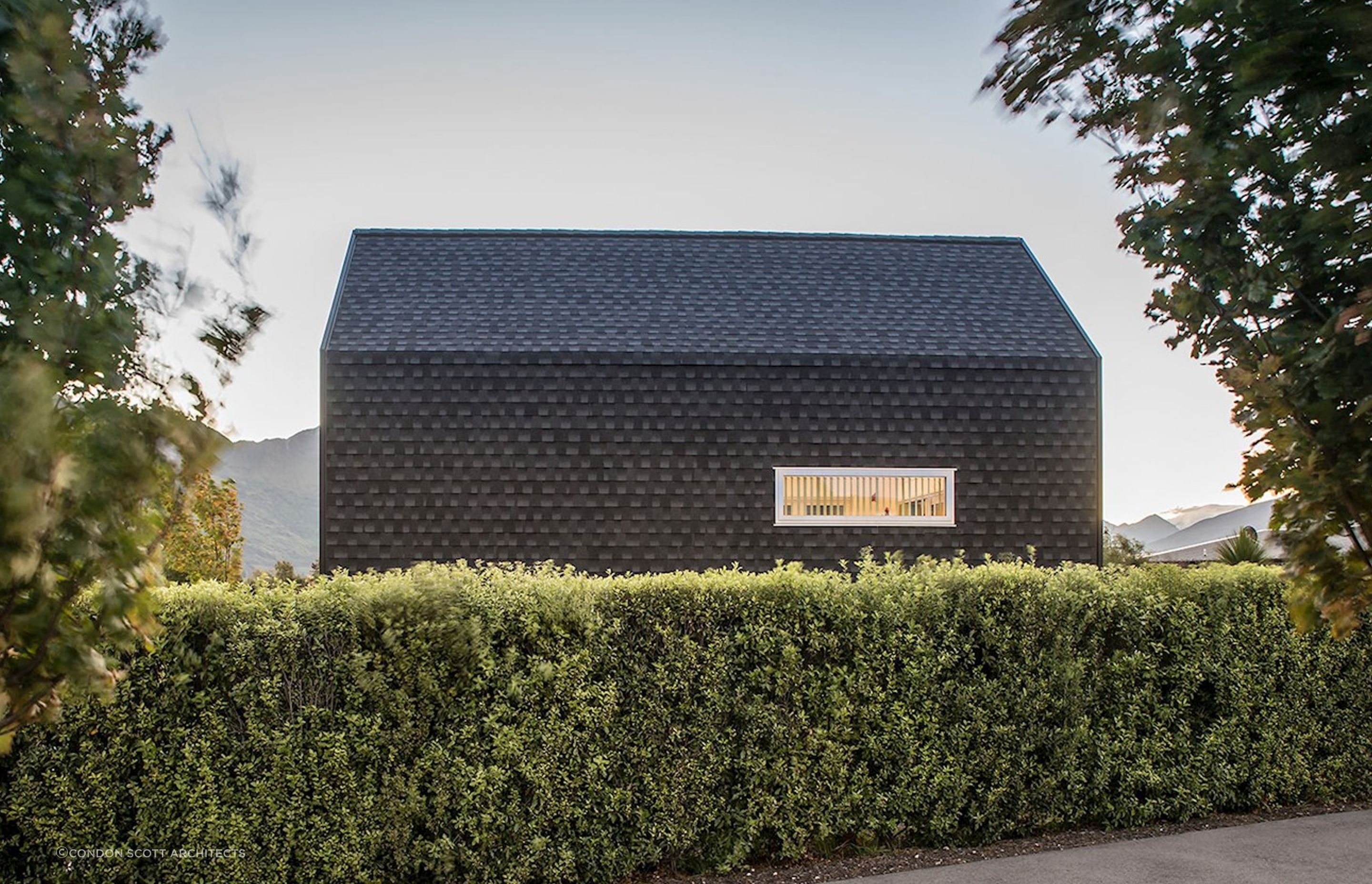 A bold kerbside view from across the hedge of the Kimimoko House