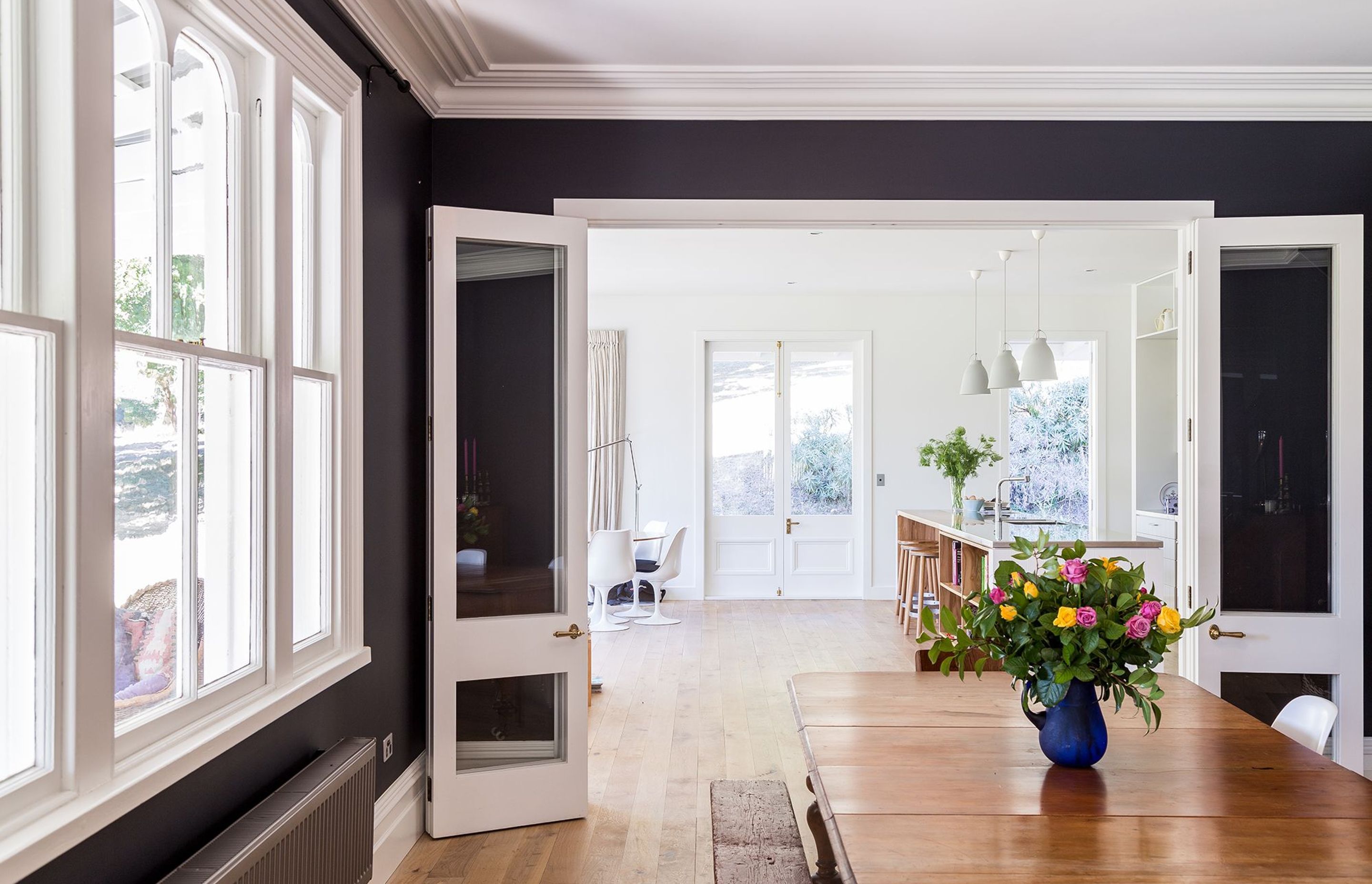 The monochromatic interior of Louden Homestead is a celebration in lightness and darkness, seen here in the dining and kitchen areas.