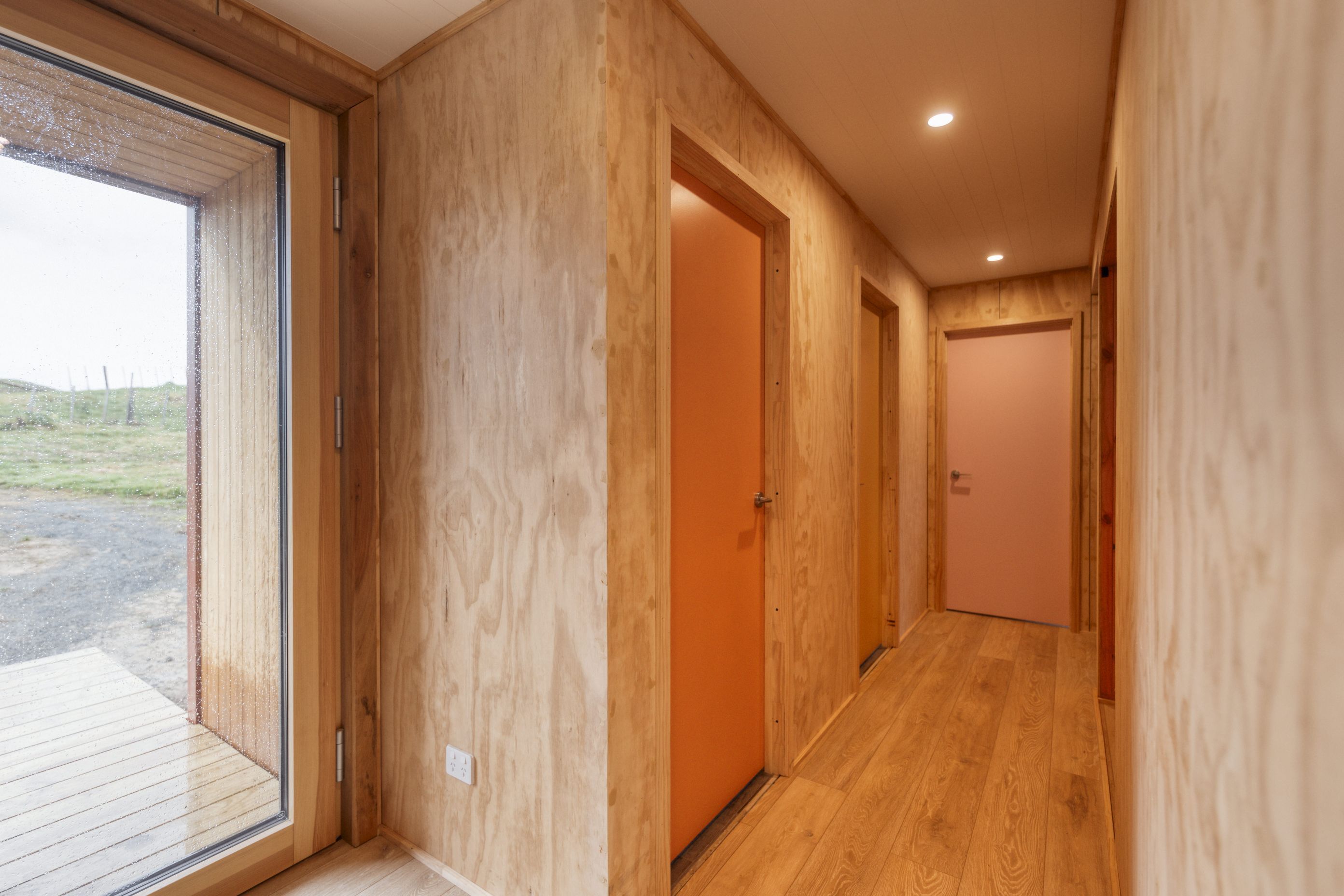 A Resene colour expert helped create a cohesive palette of seven colours for the interior doors. The oak laminate flooring throughout the downstairs area is from Bunnings.