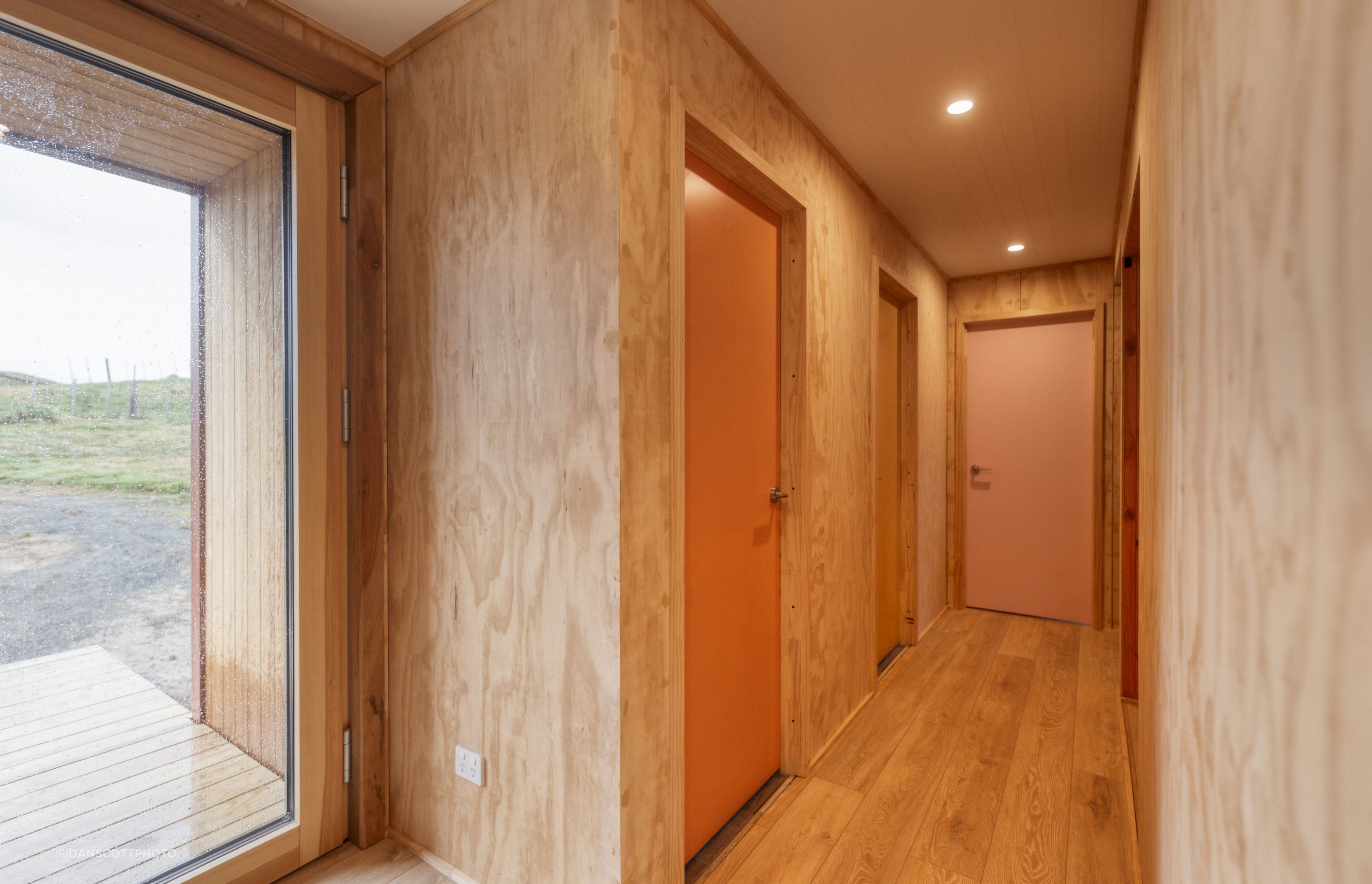 A Resene colour expert helped create a cohesive palette of seven colours for the interior doors. The oak laminate flooring throughout the downstairs area is from Bunnings.