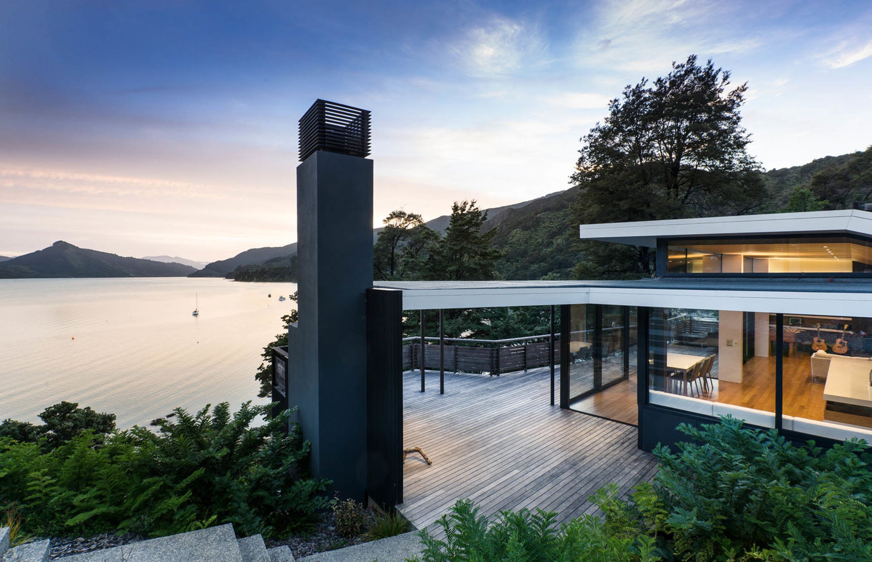 Moetapu Beach House by Parsonson Architects sits at the bottom of a steep, winding driveway and looks out to Pelorus Sound.
Its roof form helps ‘fold’ the house into the shape of the land around a small central courtyard area. Photograph by Paul McCredie.