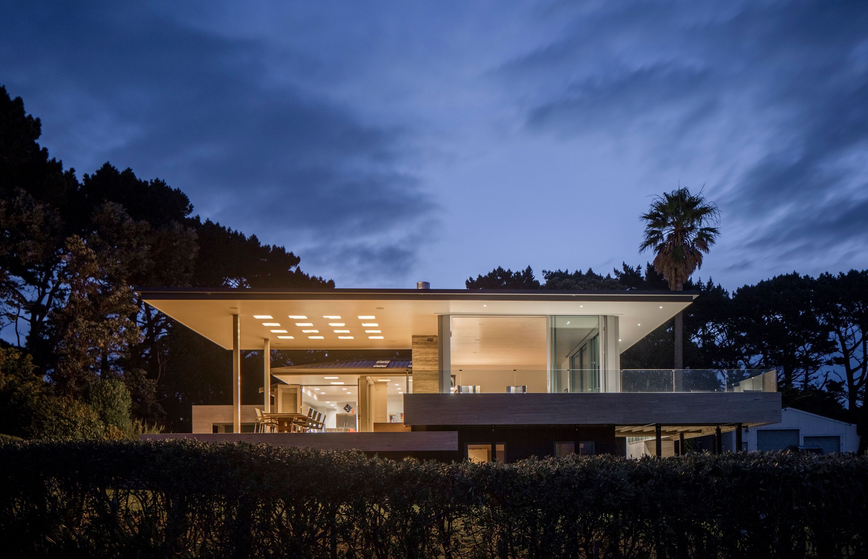 Northland Lake House by RB Studio features a 'hovering' roof punctured with square light wells diffused by honey-coloured translucent onyx stone slabs that provide a glowing ambient light at night.