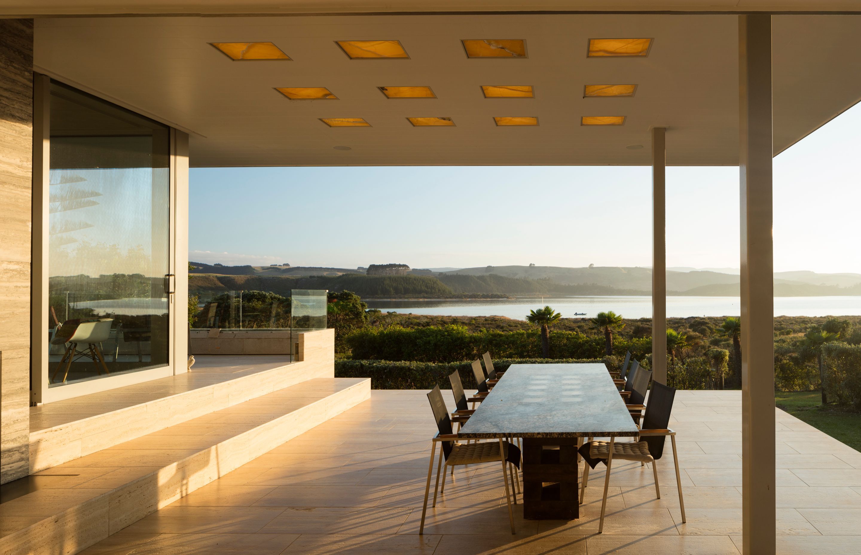 The roof is punctured with square light wells allow natural light by day, diffused by honey-coloured translucent onyx stone slabs providing a glowing ambient light in the evening, supplemented by artificial light.