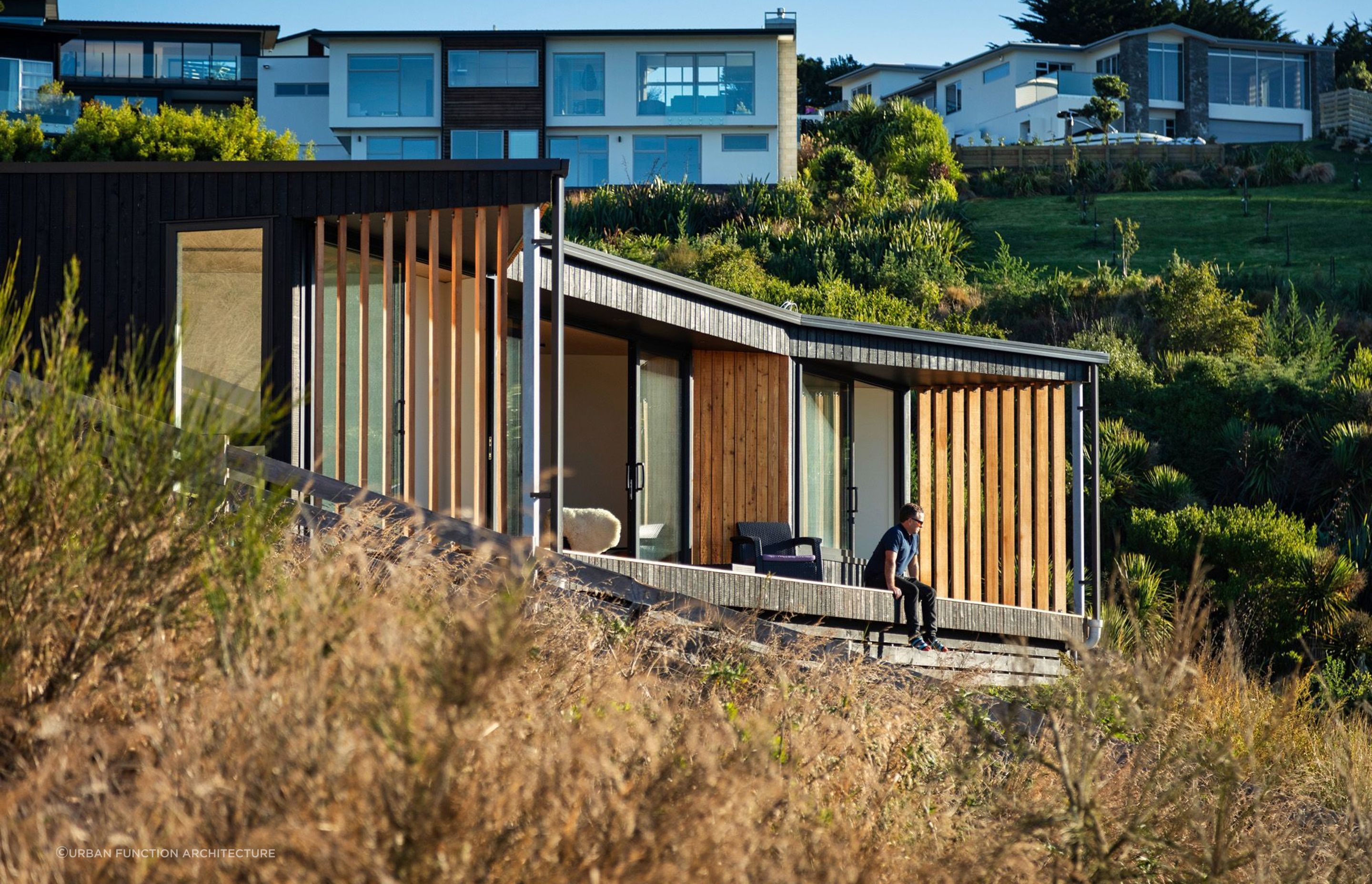 The aesthetic of the burnt and natural larch timber helps the tiny home blend seamlessly into its hillside location