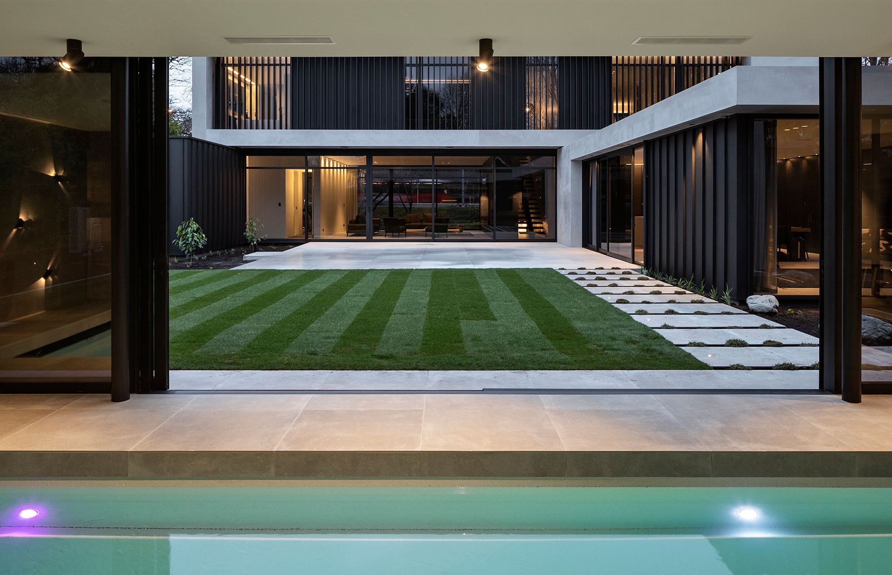 Looking across a courtyard to the house from the separate garden pavilion, which contains the swimming pool, spa and change room.