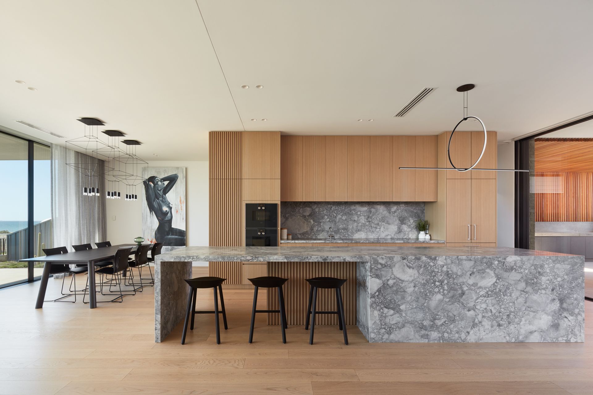 The four-and-a-half metre-long kitchen island takes centre stage in the living area | Tennyson Residence by Enzo Caroscio Architects