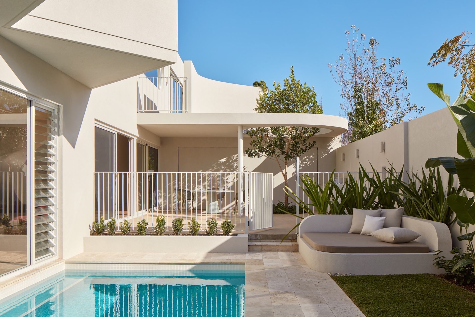 To soften the space, rich green landscaping adds complexity to the clean palette.