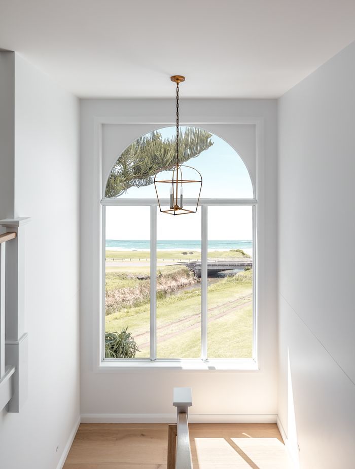 An arched stairwell window takes in the sea views.