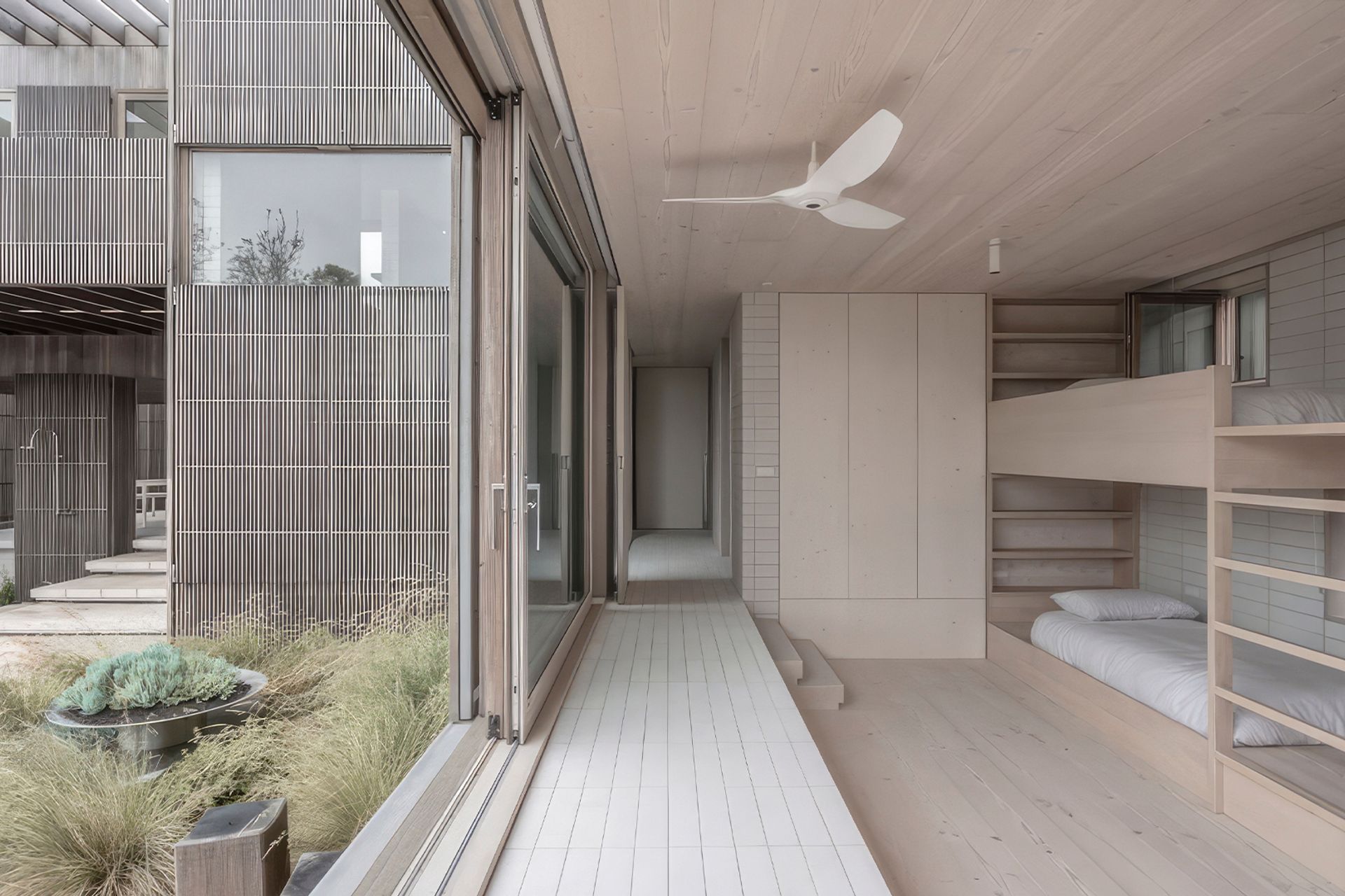 Instead of fenced-in yards, Bermagui Beach House blends together layers of sculpted landscapes that emulate the look of sand dunes and peripheral outdoor spaces.