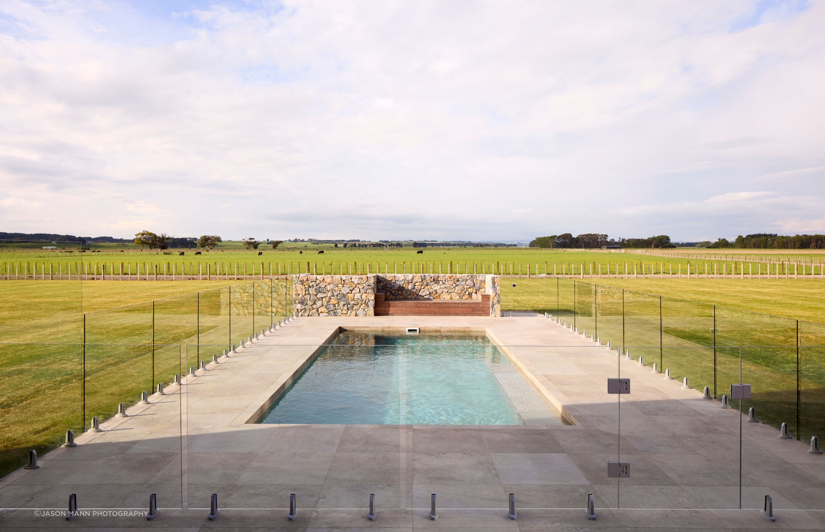 The idylic pool presents as a utopian retreat, with the farm paddocks beyond.