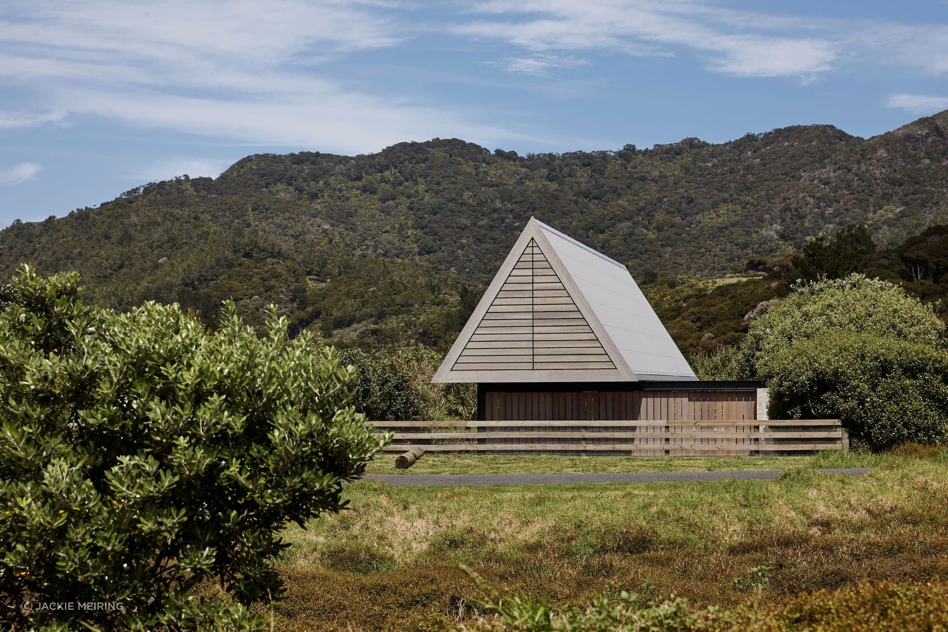 In the tradition of a Pacific a fale or simple whare occupying a coastal site, this home by RTA Studio draws its form from a simple pitched roof sheltering an open living pavilion.
