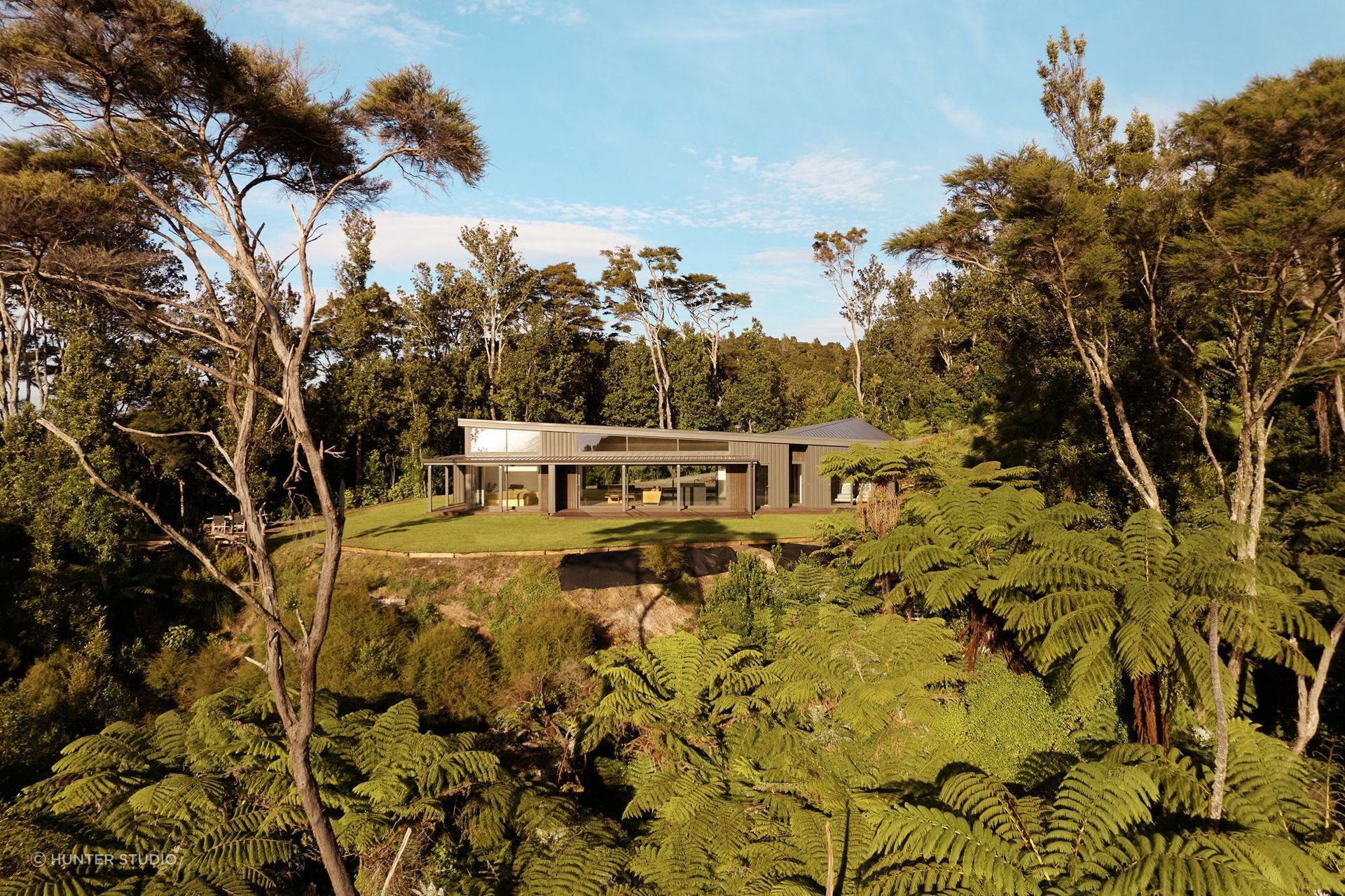 Designed for an environmentally conscious couple who love hiking, this Bay of Plenty home rests gently on its site, inspiring deep connection with the surrounding landscape through COLORSTEEL® cladding and roofing in Thunder Grey.