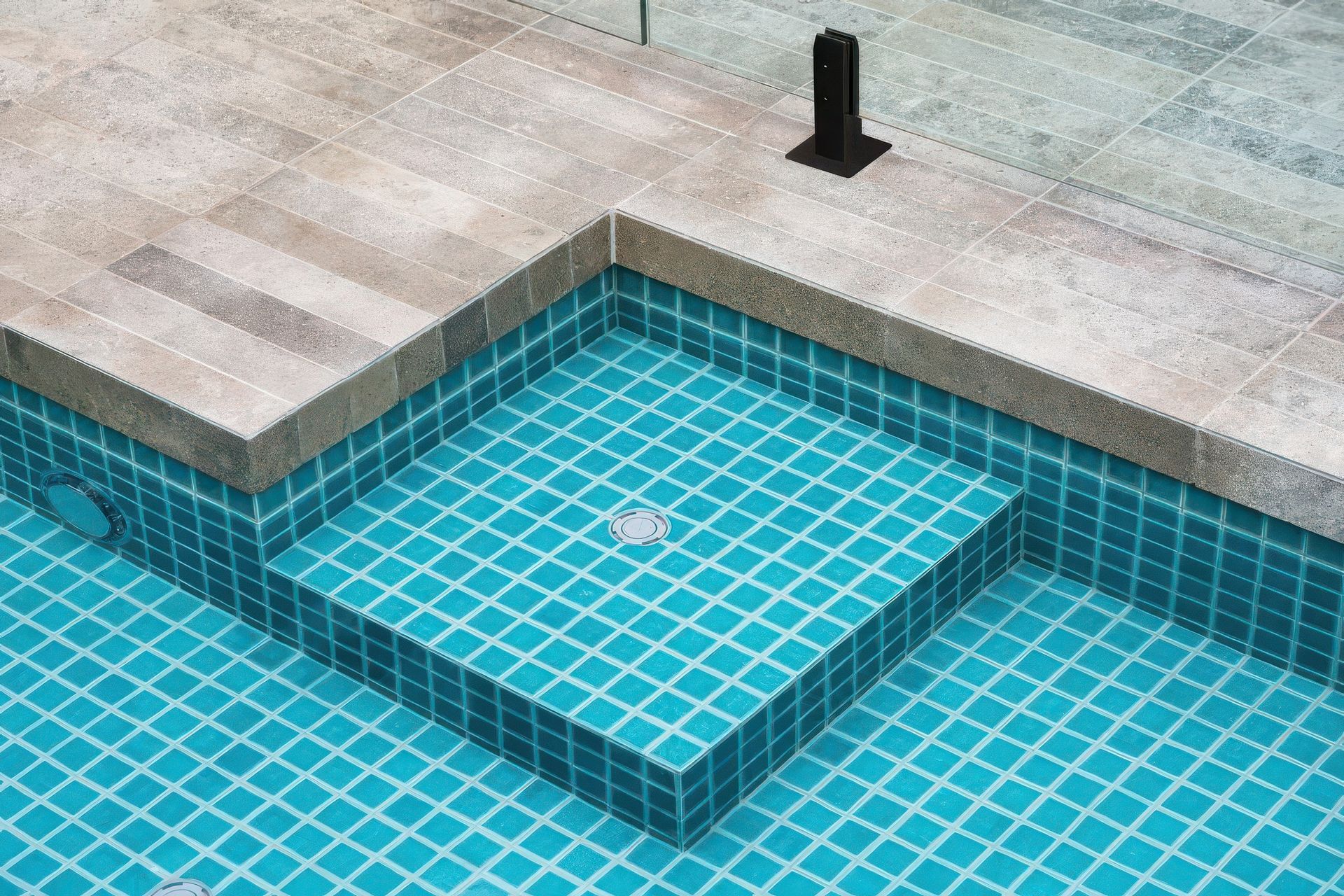 Limestone paving with Emerald Green 48×48 pool tiles. Pool by Laguna Pools.