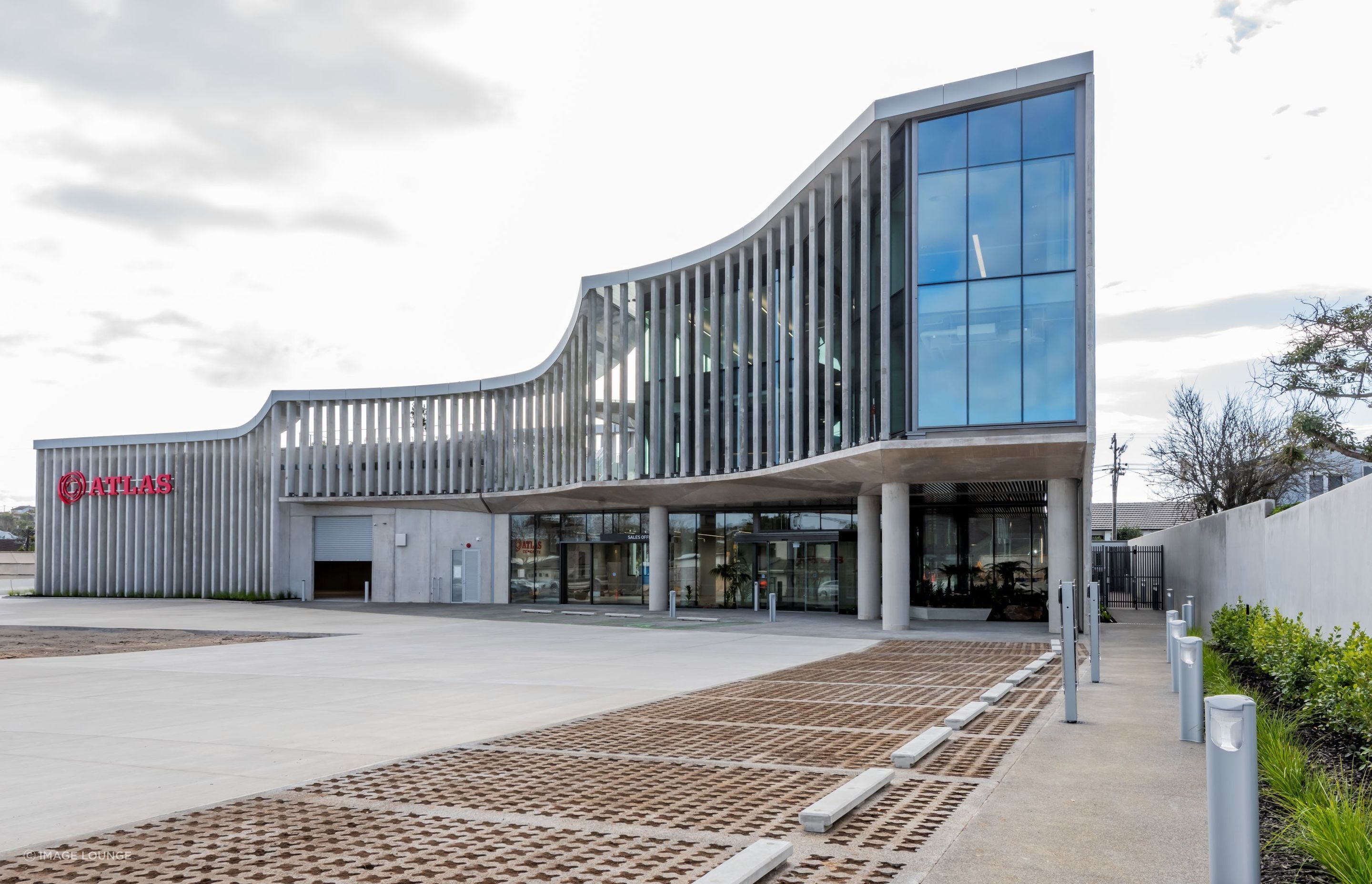 “Enveloping the fully-glazed office spaces, a veil of concrete fins serves a dual purpose: providing essential sun shading while creating a subtle barrier between the work environment and its industrial surroundings.”