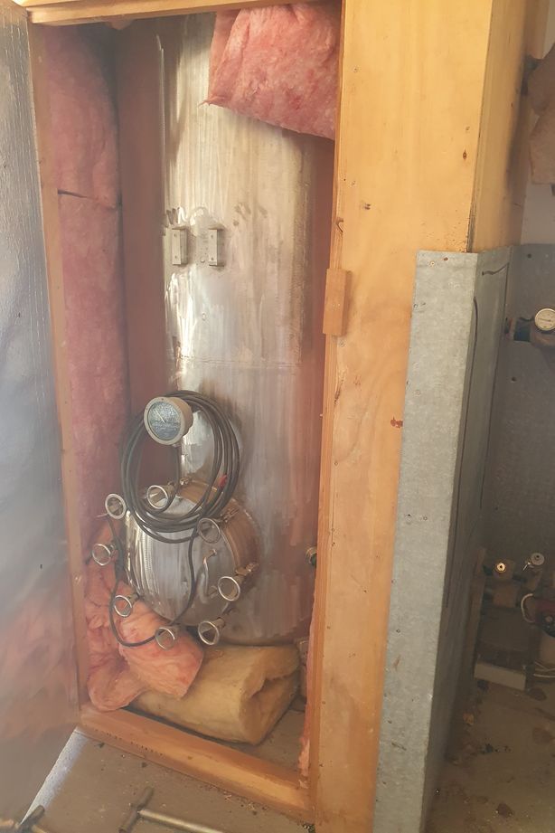 The original hot water cylinder connected to the client's multi-fuel burner.