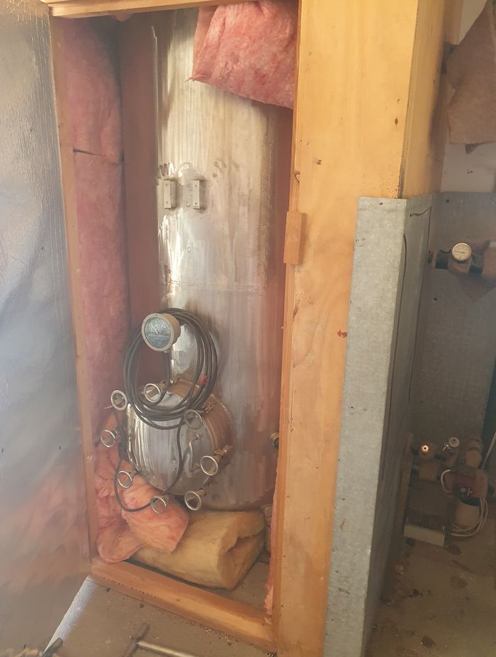 The original hot water cylinder connected to the client's multi-fuel burner.