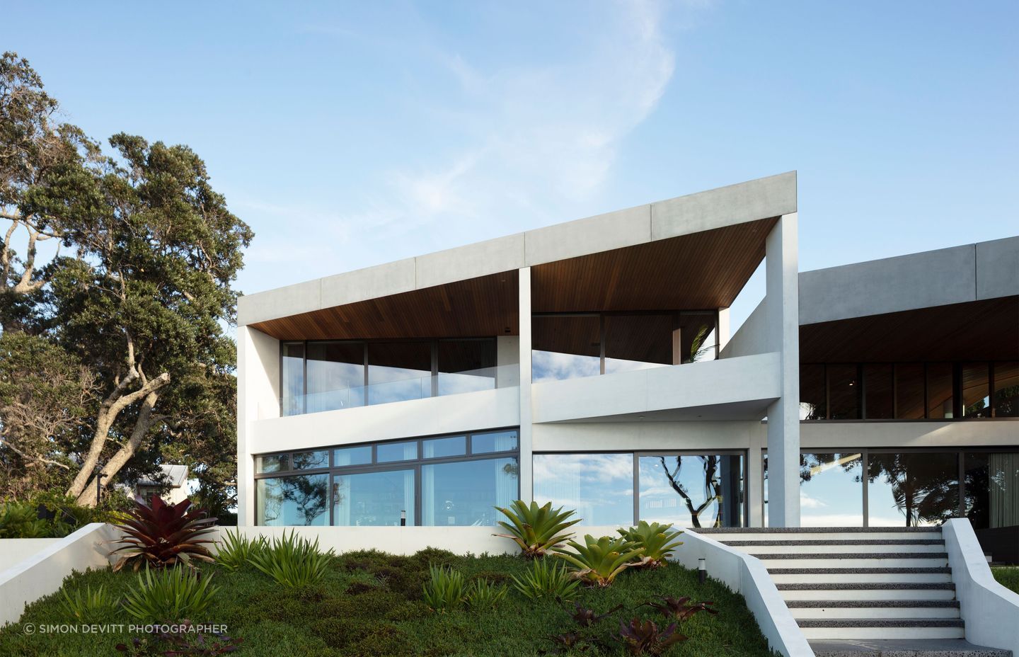 The Clifftops home by Bossley Architects connects beautifully to its site, through a sculptural beauty expressed through dyed white concrete forms.
