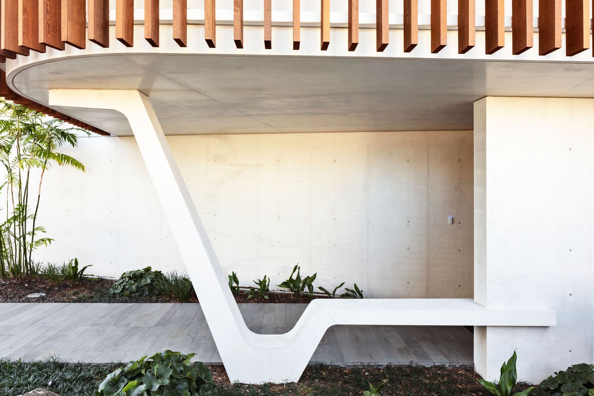 A striking sculptural element in white concrete provides a perfectly serene spot to sit and take off your shoes at the entrance of Clifftops house.
