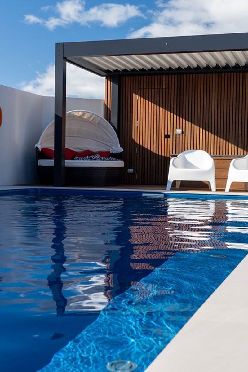 This Compass Fibreglass pool pairs effortlessly with the pergola of this outdoor space
