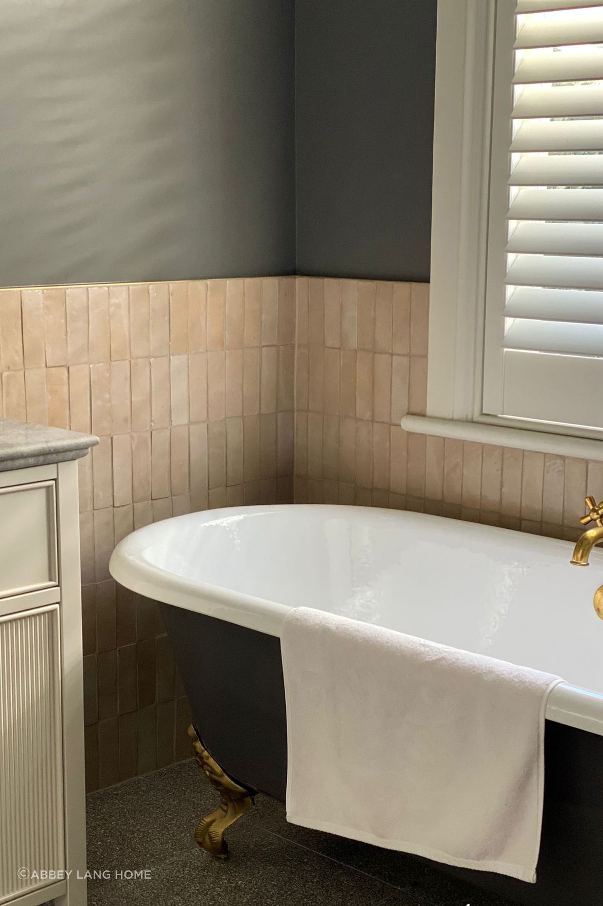 The serene single-toned palette of these zellige tiles contrasts against the bath in this Abbey Lang Home bathroom.