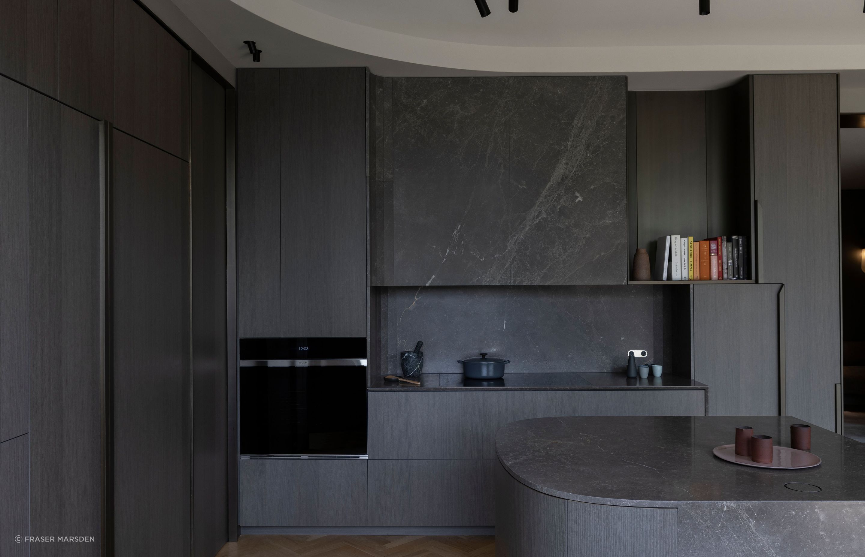 A play masculine and feminine with the blending of curves combined with sharp rectilinearity and a palette of dark, warm materials.