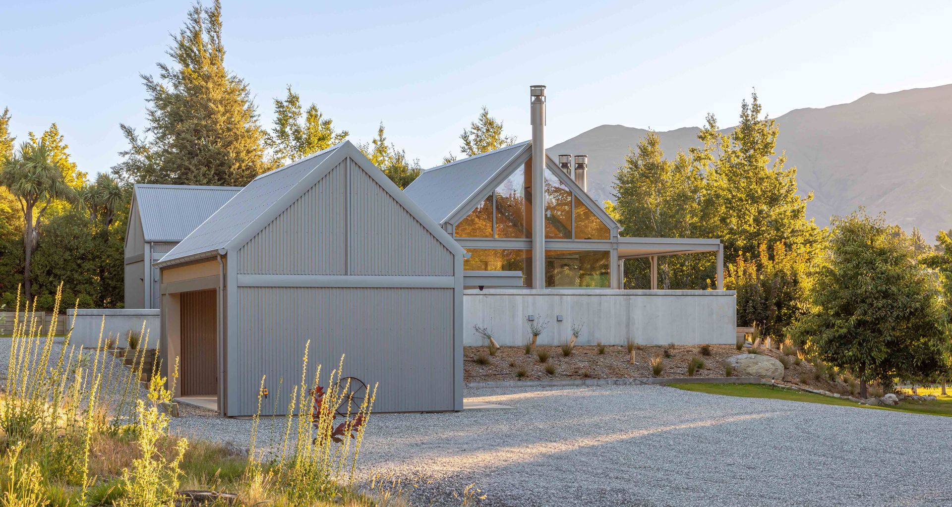 Echoing the iconic vernacular of rural structures, this holiday home on the side of Mt Iron, designed by Johnston Architects, encompasses a series of pitched roof forms wrapped in corrugated COLORSTEEL® cladding in Sandstone Grey. Image credit: John Williams.