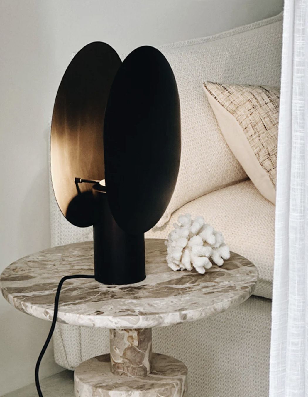 The Clam Table Lamp offers an entrancing interplay of light and shadow.