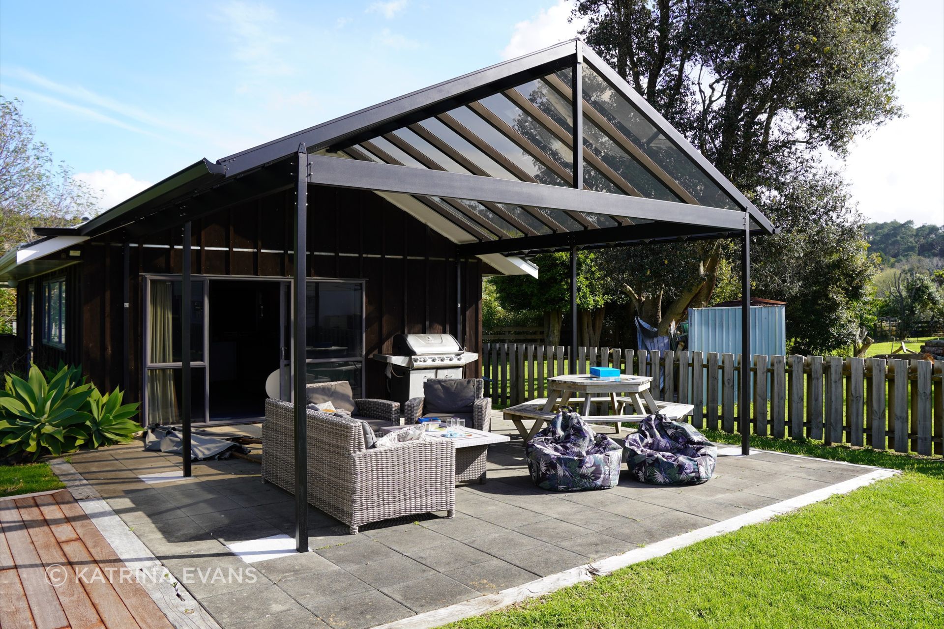 A gable-roofed canopy has doubled the living space at this Cook's Beach holiday home.