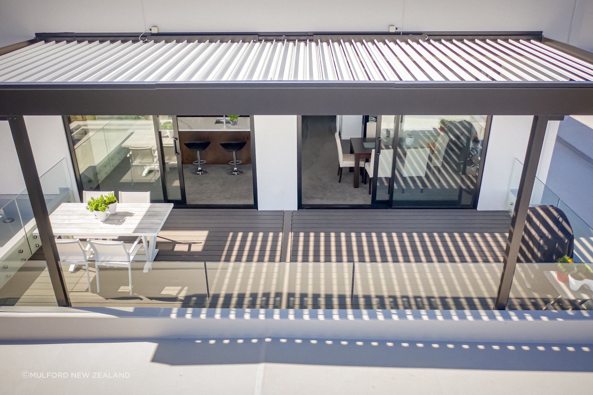 The streamlined design of Futurewood composite decking is perfectly matched with the wall-mounted pergola, creating a sanctuary away from the sun.