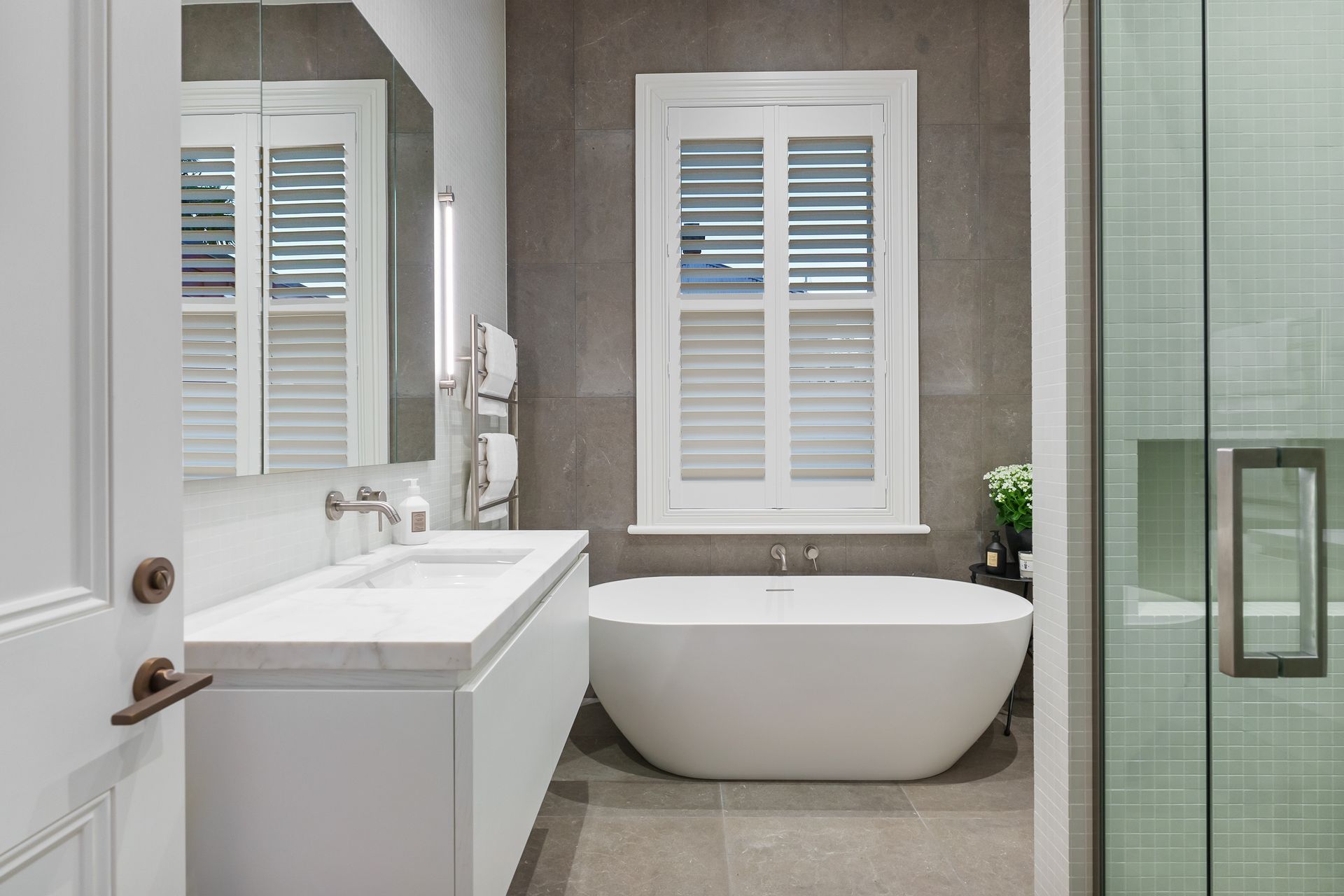 This bathroom renovation retains its era-appropriate window trim.