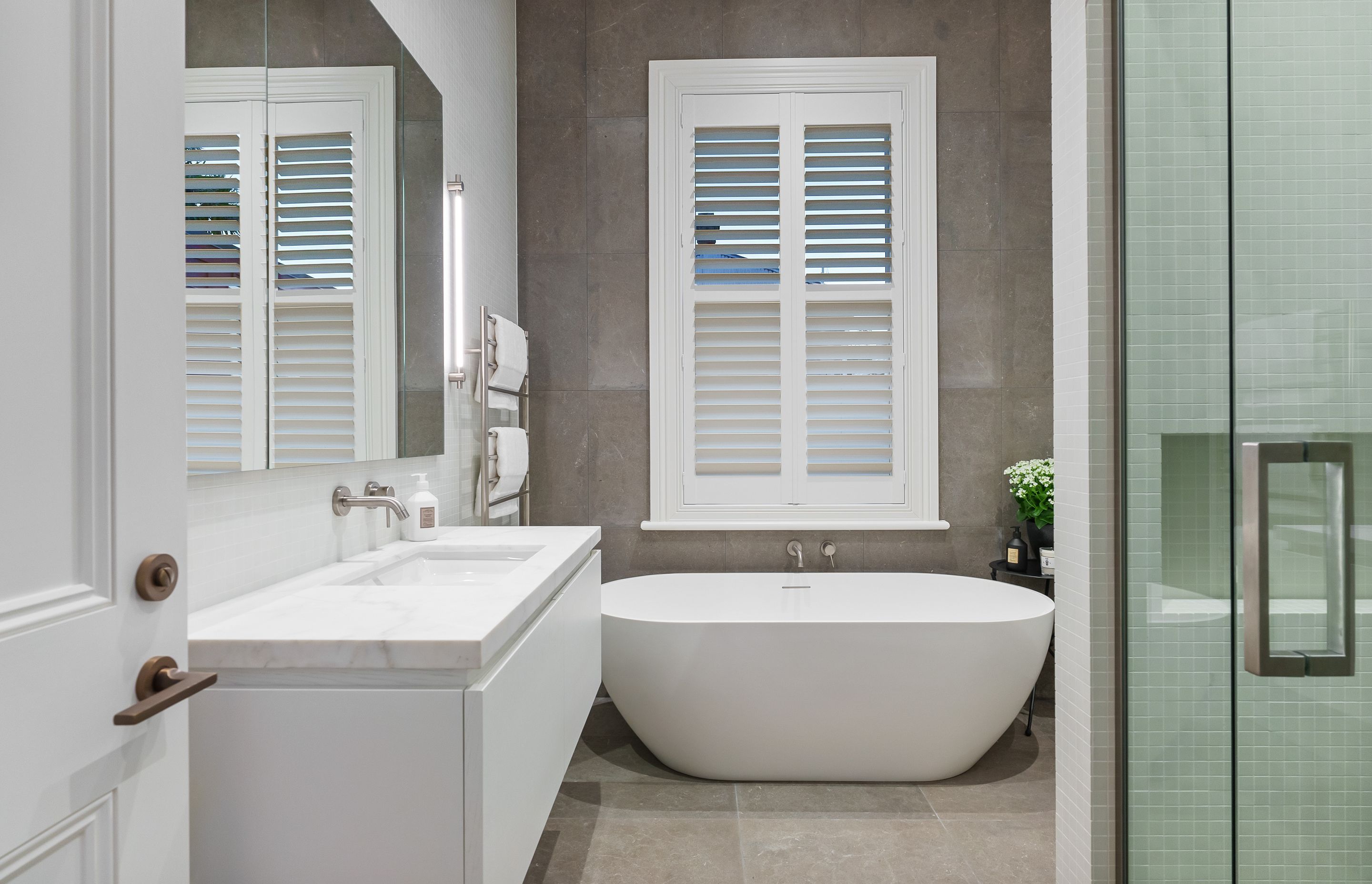 This bathroom renovation retains its era-appropriate window trim.