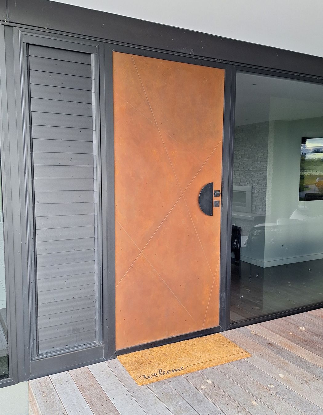 This composite door by Parkwood Doors is painted in a rustic finish to look like Corten steel.