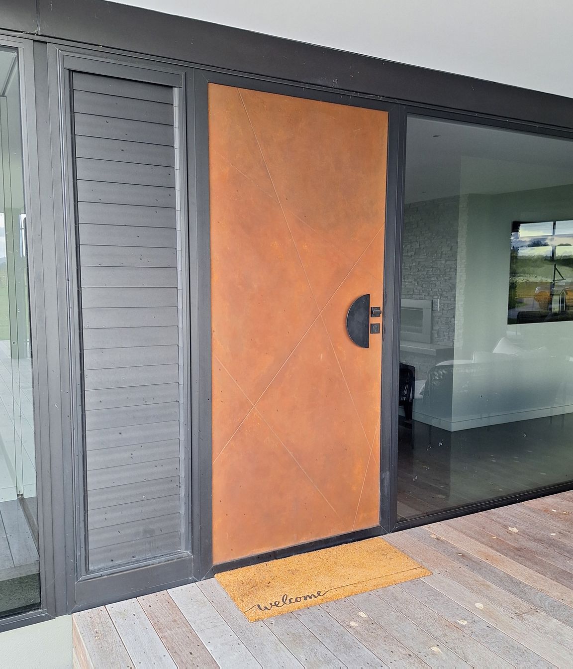 This composite door by Parkwood Doors is painted in a rustic finish to look like Corten steel.