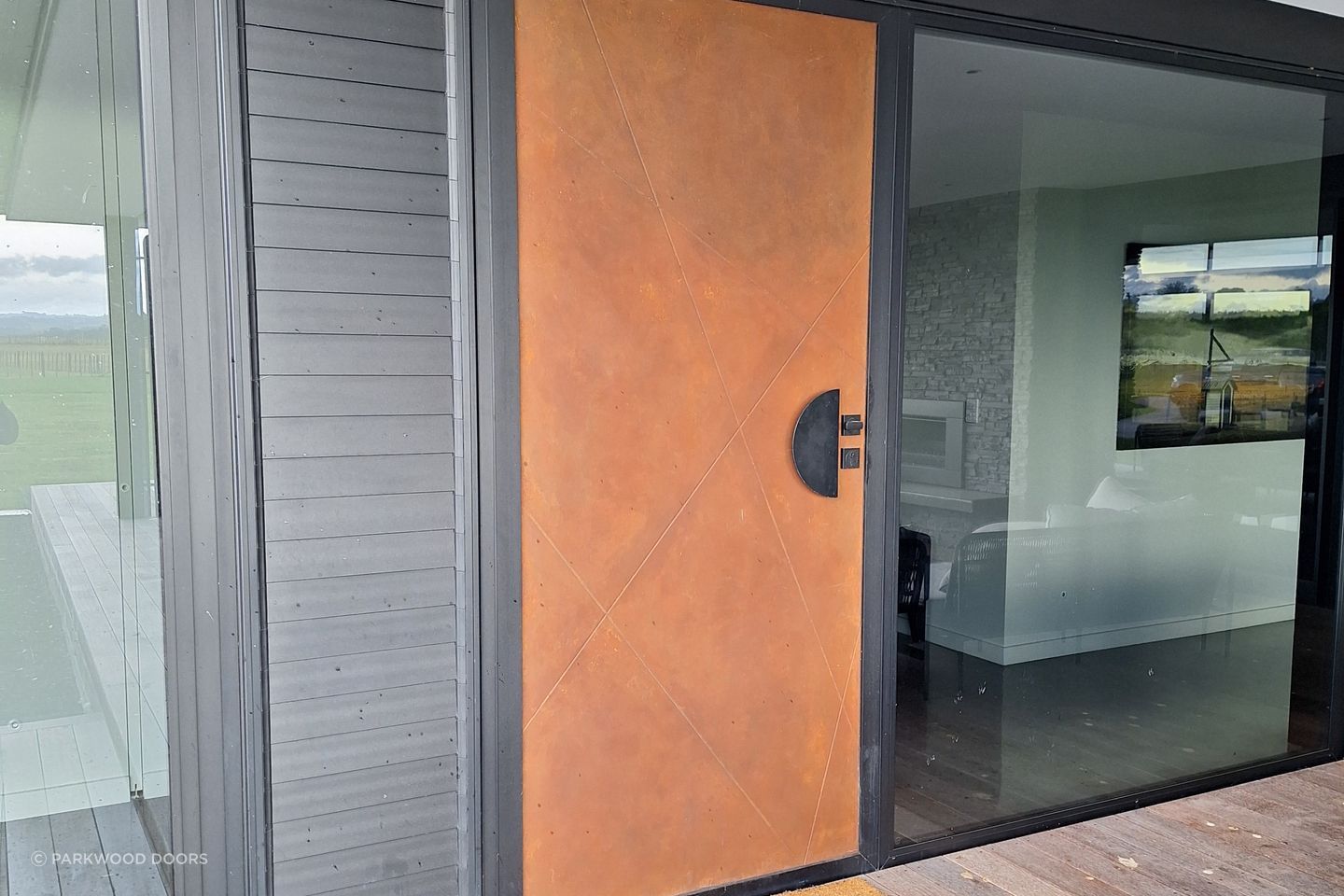 This composite door by Parkwood Doors is painted in a rustic finish to look like Corten steel.
