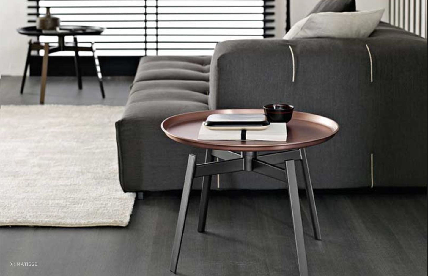 The copper finish of the Husk Small Table by B&amp;B Italia adds classical aesthetics to a living room.