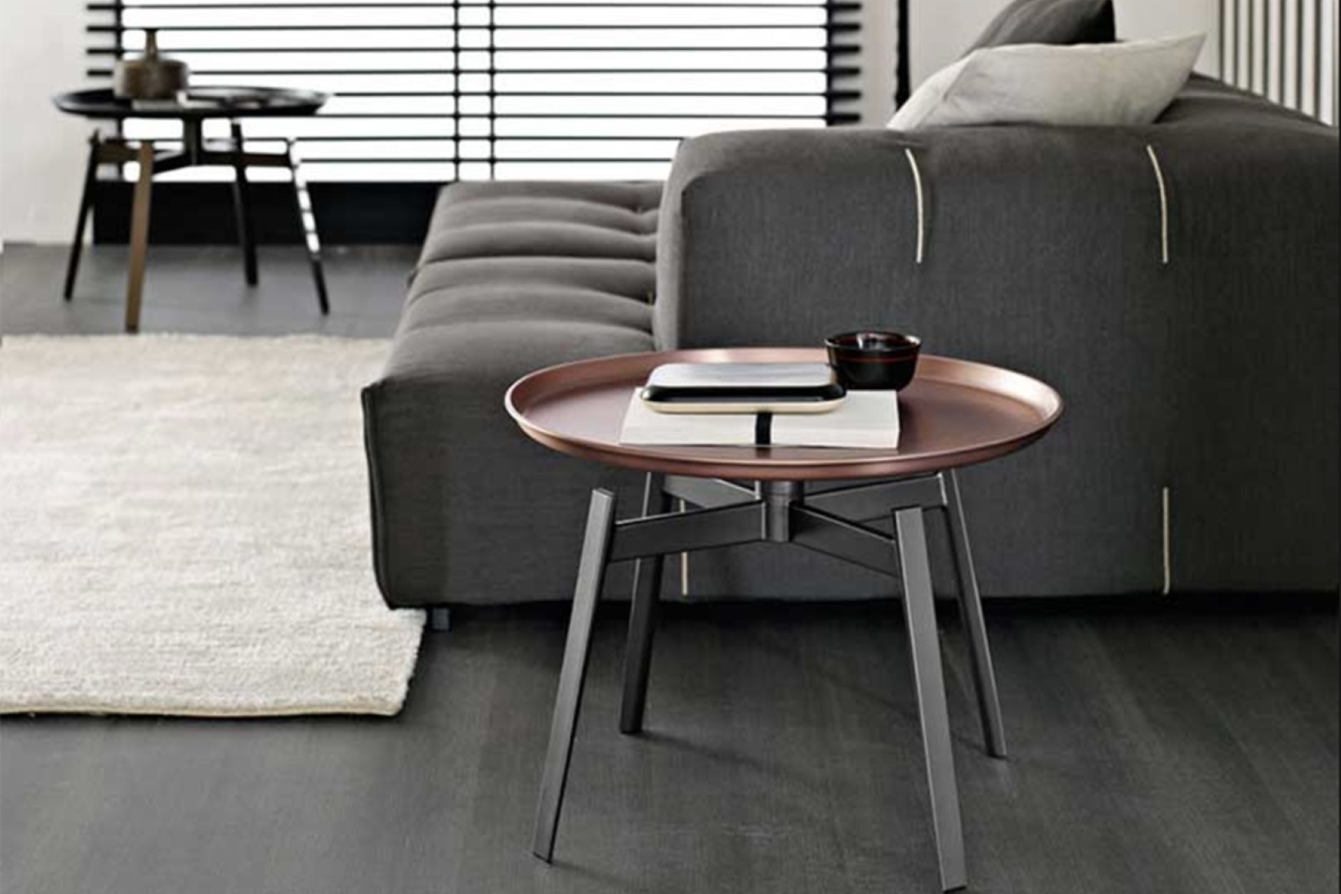 The copper finish of the Husk Small Table by B&B Italia adds classical aesthetics to a living room.