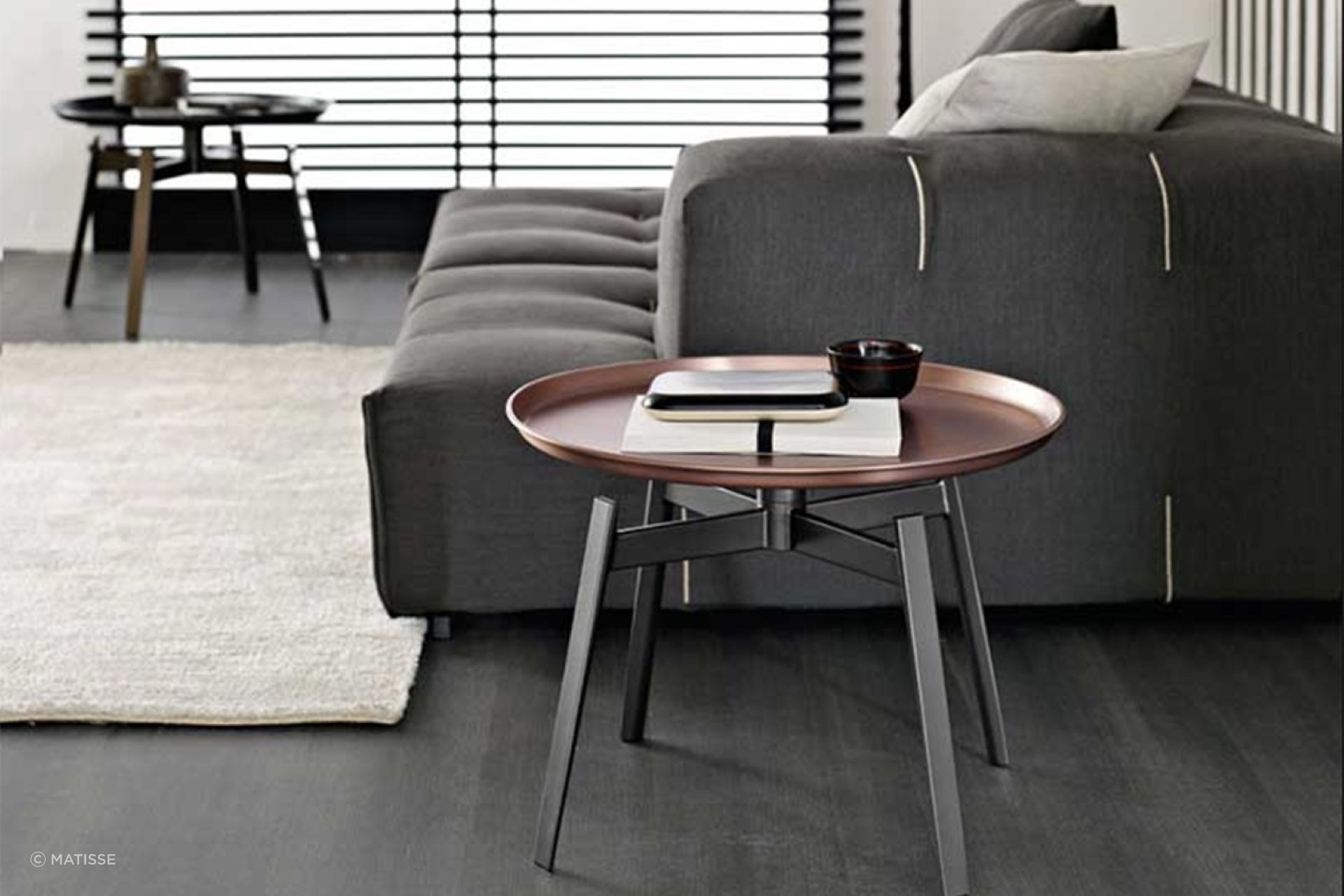 The copper finish of the Husk Small Table by B&B Italia adds classical aesthetics to a living room.